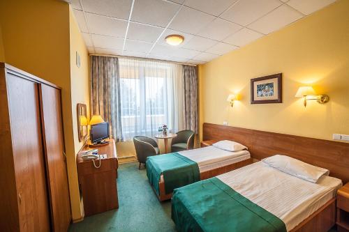 a hotel room with two beds and a television at Hotel Rychło in Bogatynia