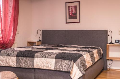 Schlafzimmer mit einem großen Bett und roten Vorhängen in der Unterkunft Ferienwohnung Steeg in Buchheim