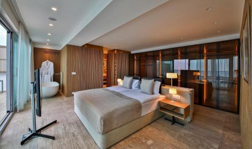 a bedroom with a large bed and a bath tub at Flamingo Grand Hotel & Spa in Albena