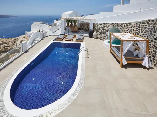 a swimming pool on the side of a villa at Celestia Grand in Fira