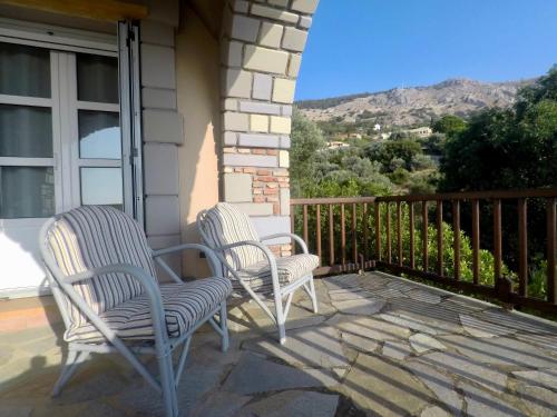 two chairs sitting on the porch of a house at Vrontados Villa in Vrontados