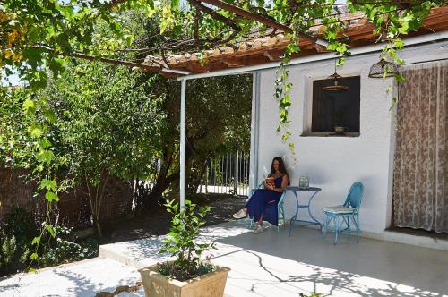 a woman sitting at a table on a patio at Moorea Country Houses in Petalidhion