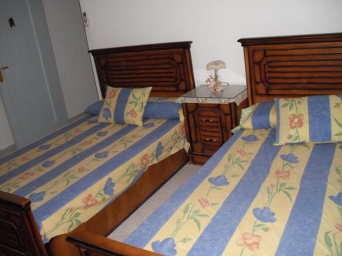 a bedroom with two beds and a table with a lamp at Reemyvera in Hurghada