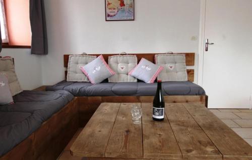a living room with a couch and a wine bottle on a table at Gite Jouvin in Cerences