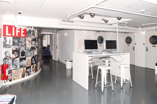 a room with a desk with two monitors and stools at City Backpackers Hostel in Stockholm