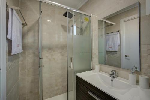 バレンシアにあるBeds & Breaks Glinkaのバスルーム(洗面台、ガラス張りのシャワー付)