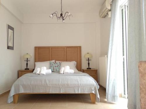 a bedroom with a bed with two pillows and a chandelier at Three Graces Holiday Houses Complex in Laganas