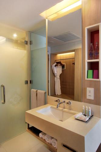 a bathroom with a sink and a large mirror at Mercure Bali Nusa Dua in Nusa Dua