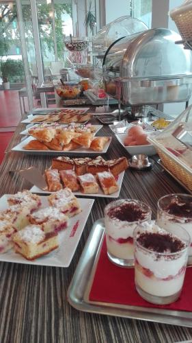 a table with different types of desserts on plates at Hotel Olympia in Kopřivnice