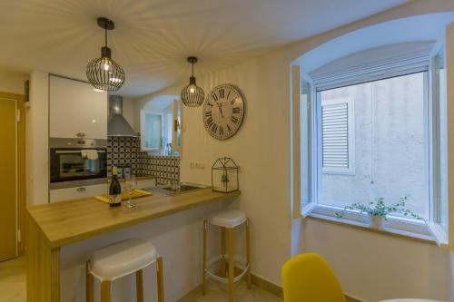 une cuisine avec un comptoir et une horloge murale dans l'établissement apartment Ivo, à Split