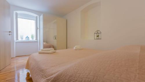 - une chambre blanche avec un grand lit et des serviettes dans l'établissement apartment Ivo, à Split