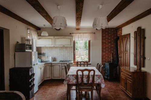 una cucina con tavolo con sedie e frigorifero di Domek Piotr 2 a Stegna