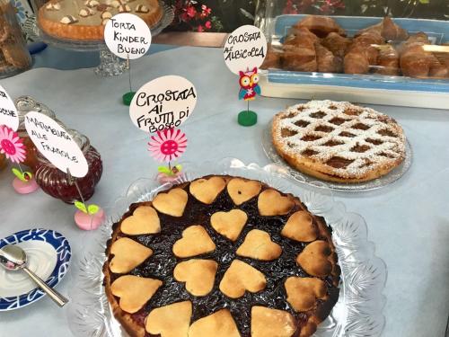 a table topped with pies and signs with cakes at Settessenze Residence & Rooms in Agropoli