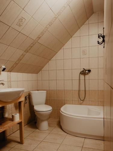 a bathroom with a toilet and a tub and a sink at Domek Piotr 2 in Stegna