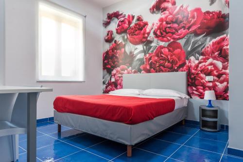 a bedroom with a red bed with a flower mural at Settessenze Residence & Rooms in Agropoli