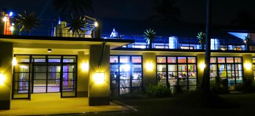 a building with a lot of windows at night at The Duyan House at Sinagtala Resort in Orani