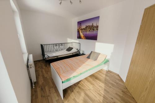 un pequeño dormitorio con una cama y una pintura en la pared en Furman Apartments Slovenja vas, en Spodnja Hajdina