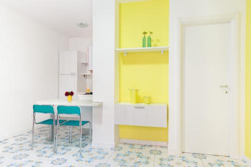a kitchen with a table and two blue chairs at Settessenze Residence & Rooms in Agropoli