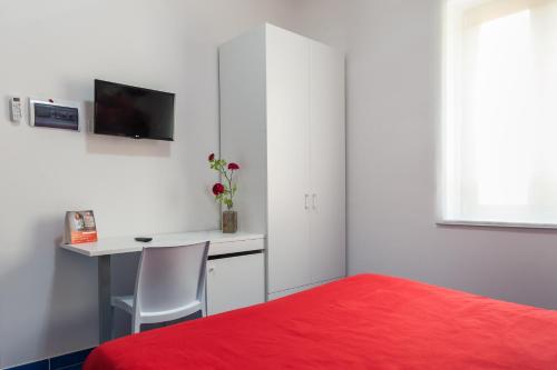 a bedroom with a desk and a red bed at Settessenze Residence & Rooms in Agropoli