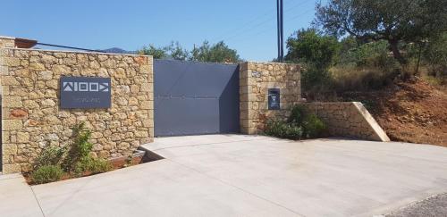 a building with a blue door and a stone wall at Lithos Guesthouse Kardamili in Kardamili