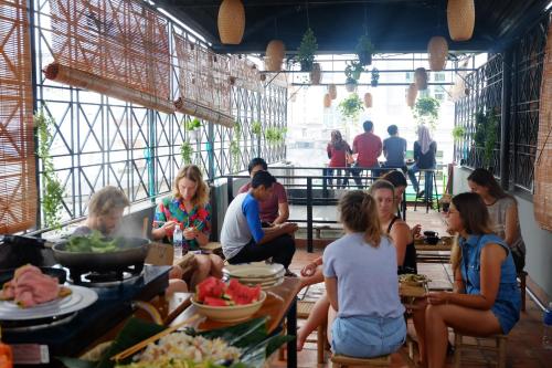 um grupo de pessoas sentadas em mesas em um restaurante em The Like Hostel & Cafe em Cidade de Ho Chi Minh