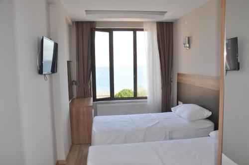 a hotel room with two beds and a window at Longoz Hotel in Igneada
