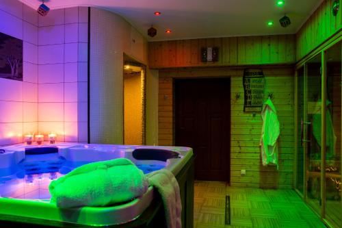 a large bathroom with a tub with green and purple lights at Hotel Carpatia Bieszczadzki Gościniec in Wetlina