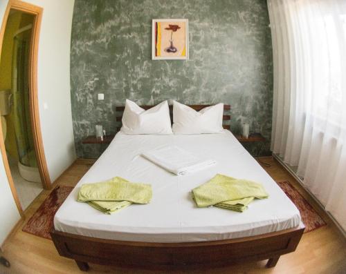 a bedroom with a bed with two towels on it at Vila Raluca in Eforie Nord