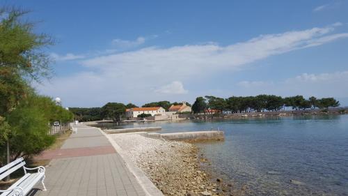 a walkway next to a body of water at Apartments Elena in Ugljan