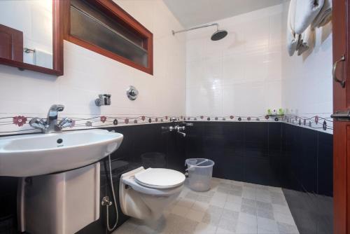 a bathroom with a white toilet and a sink at Villa Retreat - Boutique Hotel in Kodaikānāl