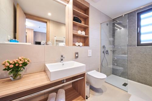a bathroom with a sink and a toilet and a shower at Garden Suites Umag Plava Laguna in Umag