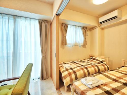 ein Hotelzimmer mit 2 Betten und einem Fenster in der Unterkunft Mango Resort Okinawa Chatan in Chatan