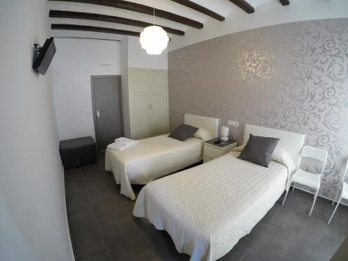 a hotel room with two beds and a mirror at Hostal Mediterráneo in Tossa de Mar