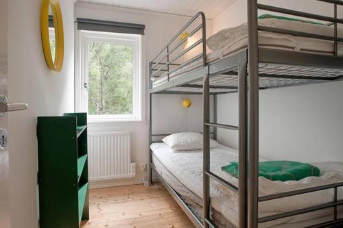 1 dormitorio con 2 literas y ventana en Archipelago-house with pool, boat and bikes en Djurhamn