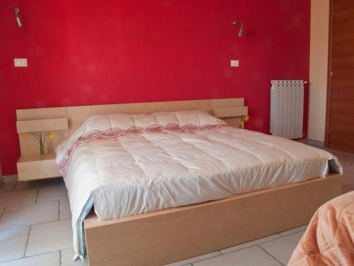 ein Bett in einem Schlafzimmer mit einer roten Wand in der Unterkunft B&B La Rosa dei Venti in Montesilvano