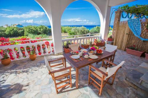 a table and chairs on a patio with a view of the ocean at Ammos Apartments in Alikanas