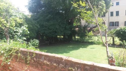 a yard with a wall and trees and a building at Locanda Ca' del Brocchi in Venice