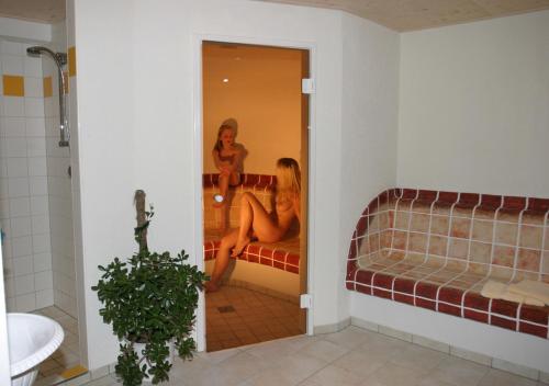 a woman sitting on a couch in a bathroom at Landhaus Lührmann in Ramsau am Dachstein