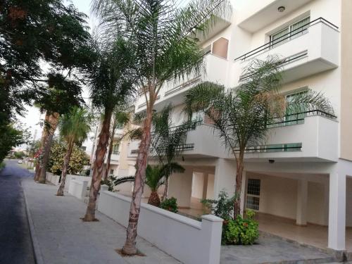 a building with palm trees in front of it at Marianna Hotel Apartments in Limassol