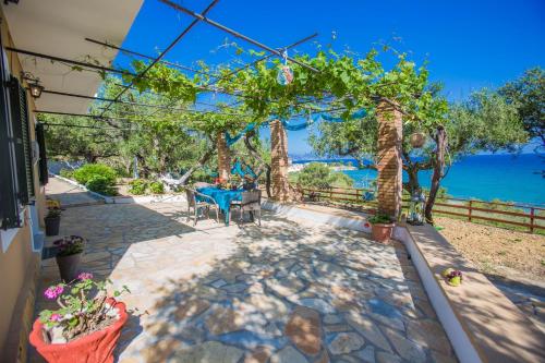 a house with a patio with a view of the ocean at Ammos Apartments in Alikanas