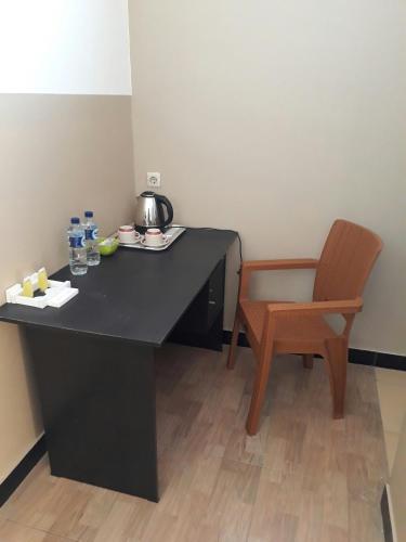 a black desk with a tea kettle and a chair at The New Orlinds Guest House in Wonosari