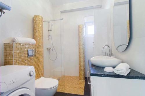 uma casa de banho com um lavatório, um WC e um chuveiro em Apartments Maky & Dino em Vodice