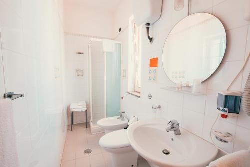 bagno bianco con lavandino e servizi igienici di Apulia Hotel Corigliano Calabro a Corigliano Calabro