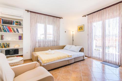 een slaapkamer met een bed en een boekenplank bij Apartment "On the beach" in Trogir
