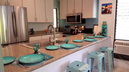 a kitchen counter with plates and utensils on it at Maui Tranquility in Kihei
