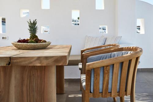 a table and chairs with a bowl of fruit on it at Volcano View by Caldera Collection in Fira