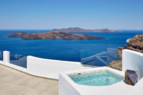 a jacuzzi tub on a balcony overlooking the ocean at Volcano View by Caldera Collection in Fira