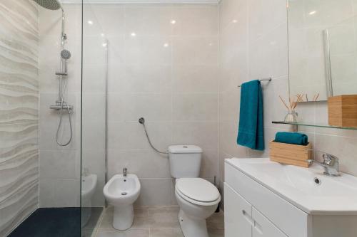 a bathroom with a toilet and a shower and a sink at Apartamento Ocean Dreams in Quarteira