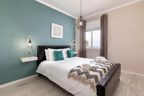 クアルテイラにあるApartamento Ocean Dreamsの青い壁のベッドルーム1室(大型ベッド1台付)