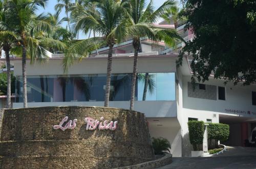 a building with palm trees in front of it at Las Brisas Acapulco in Acapulco